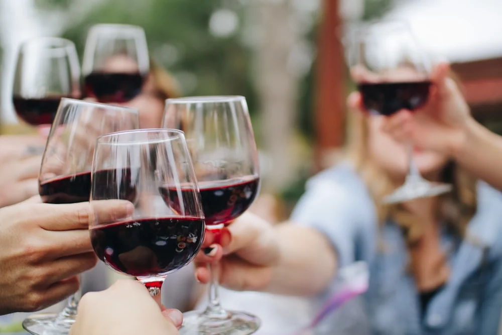 Des verres de vin prêts à être partagés autour d’une belle table